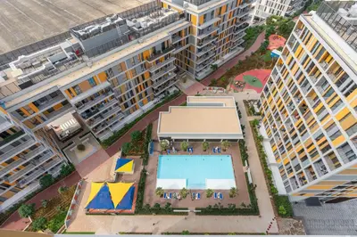 an overhead view of a building with a swimming pool at Vacay Lettings - Spacious Studio Apartment - Production City in Dubai