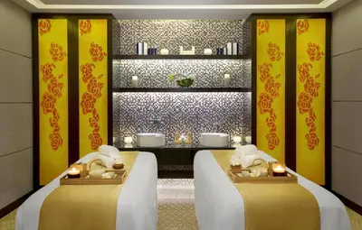 two beds in a room with yellow walls and candles at Luxurious 1bhk in Cour Jardin in Dubai