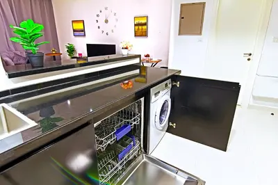 a washer and dryer in a kitchen at Luxurious 1bhk in Cour Jardin in Dubai