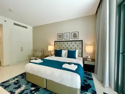 a bedroom with a large bed with blue and white sheets at Vacay Lettings - Modern Studio Near to Expo City in Dubai