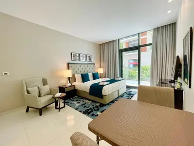a hotel room with a bed and a table and chairs at Vacay Lettings - Modern Studio Near to Expo City in Dubai