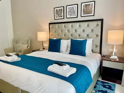 a bedroom with a large bed with two towels at Vacay Lettings - Modern Studio Near to Expo City in Dubai