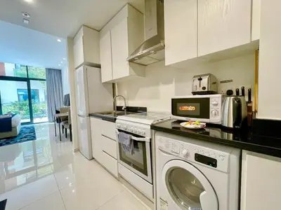 a kitchen with a washing machine and a microwave at Vacay Lettings - Modern Studio Near to Expo City in Dubai
