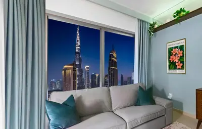 a living room with a couch and a window with a view of the city at Front Row Burj Khalifa Views - Dubai Mall Access - Premium 2BDR in Dubai