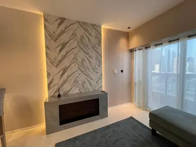 a living room with a fireplace and a couch at Dubai Gate 1 in Dubai