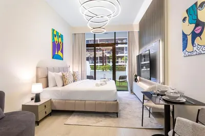 a bedroom with a king sized bed and a living room at Sleek Studio Apartment in Azizi Riviera in Dubai