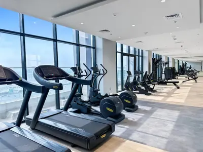 a gym with treadmills and ellipticals in a building at Sleek Studio Apartment in Azizi Riviera in Dubai