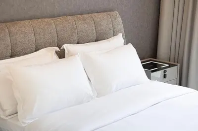 a bed with white pillows in a hotel room at Modern Stylish 2 Bedroom Apartment with Burj Khalifa View in Dubai