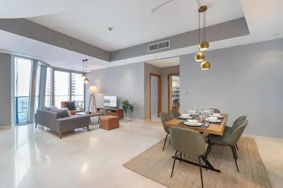 a dining room and living room with a table and chairs at Premium 2 Bedroom in Trident Residence JBR in Dubai