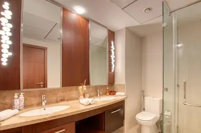 a bathroom with a sink and a toilet and a mirror at Stylish 2 Bedroom Opera View in Downtown Dubai SP2013 in Dubai