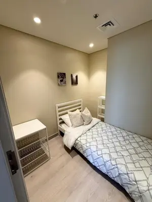 a small bedroom with a bed and a table at Upgraded brand new apartment Downtown in Dubai