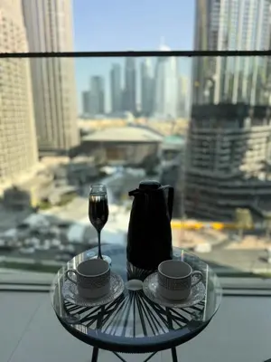 a glass table with two cups and a glass of wine at Upgraded brand new apartment Downtown in Dubai
