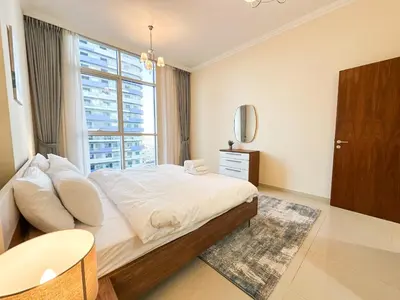 a bedroom with a large bed and a window at Elegant 1BR in Dunya Tower, Downtown Dubai 12AB10 in Dubai