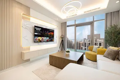 a living room with a flat screen tv on a wall at 5Star Stunning 2BR BURJ Khalifa View with Infinity Pool in Dubai