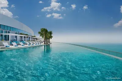 a swimming pool with chairs and the ocean in the background at Luxury Escape w Stunning Views Address JBR 1BR in Dubai
