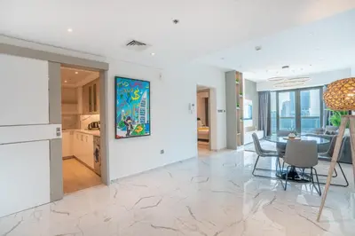 a living room with a dining room and a kitchen at RH -Luxury 1BR, Large Balcony & High-End Interiors, Downtown in Dubai