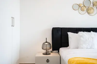 a bedroom with a bed and a lamp on a night stand at RH -Luxury 1BR, Large Balcony & High-End Interiors, Downtown in Dubai