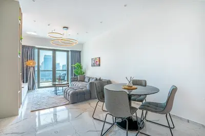 a living room with a table and a couch at RH -Luxury 1BR, Large Balcony & High-End Interiors, Downtown in Dubai