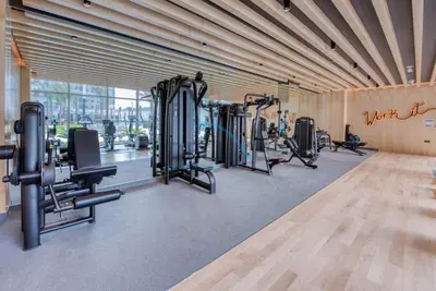 a gym with a row of treadmills and machines at Peaceful 1BR in Bella Rose Al Barsha South by Deluxe Holiday Homes in Dubai