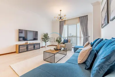 a living room with a blue couch and a tv at Stunning 2BR with Assistant Room in MAG 214, Jumeirah Lake Towers by Deluxe Holiday Homes in Dubai
