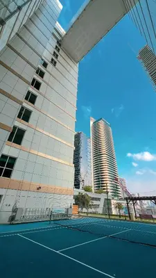 a tennis court in front of a building at 3BR Luxury Escape at Mon Reve I Access to Pool and Gym in Dubai