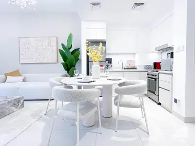 a white kitchen with a white table and chairs at Luxury Design & Stunning Views in Dubai Hills in Dubai