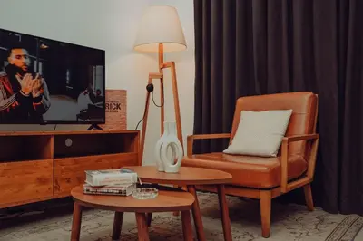 a living room with a chair and a tv at Elegant Studio Downtown 5 Minute Walk to Burj Khalifa & Dubai Mall in Dubai