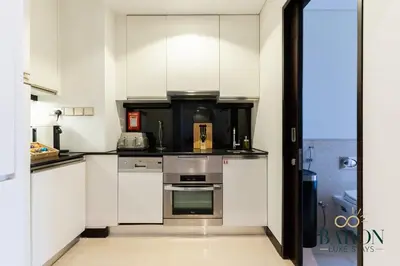 a kitchen with white cabinets and stainless steel appliances at The Classic in Dubai