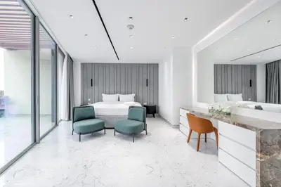 a bedroom with a bed and two chairs at Grand Dubai Marina 4BR Triplex with Pool Gym Sauna in Dubai
