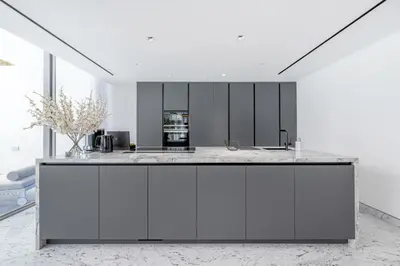 a kitchen with white cabinets and a counter top at Grand Dubai Marina 4BR Triplex with Pool Gym Sauna in Dubai