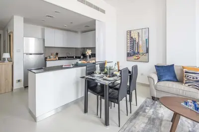 a kitchen and living room with a table and a couch at Frank Porter - Pulse C1 in Dubai