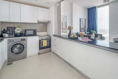 a kitchen with a washing machine and a washer and dryer at Frank Porter - Pulse C1 in Dubai