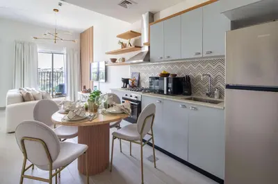 a kitchen with a table and chairs and a kitchen with a dining room at Frank Porter - Golf Vile in Dubai