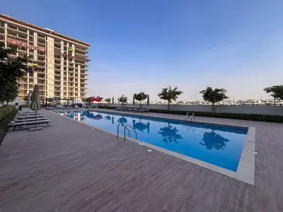 a swimming pool next to a large building at Frank Porter - Golf Vile in Dubai