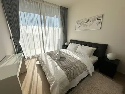 a bedroom with a bed and a large window at Sleek 1br Apt Jvc Quiet Space With Pool & Par in Dubai