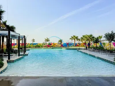 a large swimming pool in a amusement park at Unbeatable Rate Modern 2BR with Partial Canal Views by Deluxe Holiday Homes in Dubai