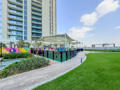 a playground in a park next to a tall building at Unbeatable Rate Modern 2BR with Partial Canal Views by Deluxe Holiday Homes in Dubai