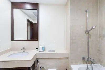 a bathroom with a sink and a mirror and a shower at FIRST CLASS 2BR Burj Khalifa & Fountain View in Dubai