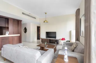 a living room with a couch and a tv at FIRST CLASS 2BR Burj Khalifa & Fountain View in Dubai