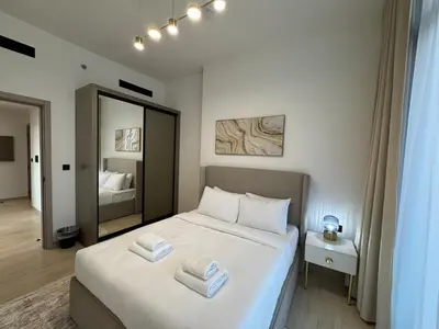 a bedroom with a bed with two towels on it at ASHRI HH Spacious Apartment in JVC, Binghatti Luna in Dubai