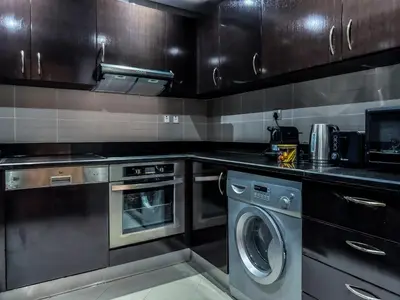 a kitchen with a washing machine and a washer at Picture-Perfect 2BR apartment with Burj View in Dubai