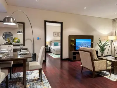 a living room with a dining table and a bedroom at Picture-Perfect 2BR apartment with Burj View in Dubai