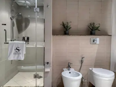 a bathroom with a shower and a toilet and a sink at Picture-Perfect 2BR apartment with Burj View in Dubai