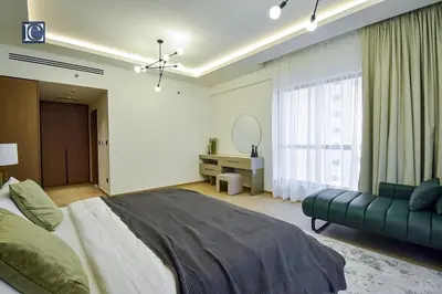 a bedroom with a large bed and a green couch at Luxury Escapes - Elegant 3 Bedroom plus Maids Room Apartment in JBR in Dubai