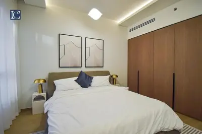 a bedroom with a large bed with two pictures on the wall at Luxury Escapes - Elegant 3 Bedroom plus Maids Room Apartment in JBR in Dubai