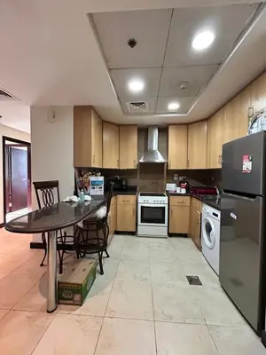 a kitchen with a table and a refrigerator at Click Stay - JLT - 2 Bedroom & Balcony Lakes view Entire Apartment -AZ in Dubai