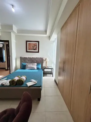 a bedroom with a blue bed and a wooden cabinet at Click Stay - JLT - 2 Bedroom & Balcony Lakes view Entire Apartment -AZ in Dubai