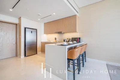 a kitchen with a counter and some chairs in it at LUX Iconic Views at The Palm Tower Suite 5 in Dubai