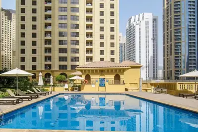 a large swimming pool in a city with tall buildings at Palm & Sea View 2BR JBR Beach Oasis 1 in Dubai