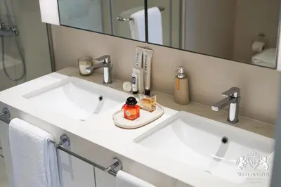 a bathroom with two white sinks and a mirror at Westminster Beach Front in Dubai